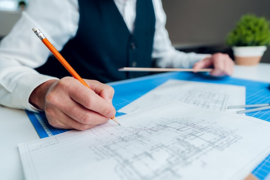 Close up of hand of an architect, engineer drawing blueprint