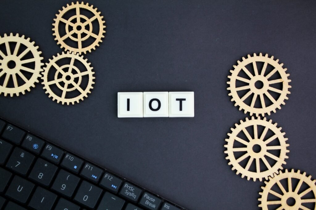 laptop keyboard and gear teeth with IOT alphabet word.